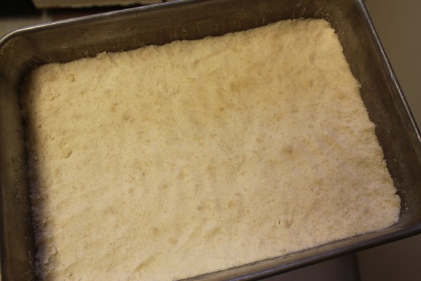 Press the dough into a 9-by-13-inch pan. Make sure it's even!