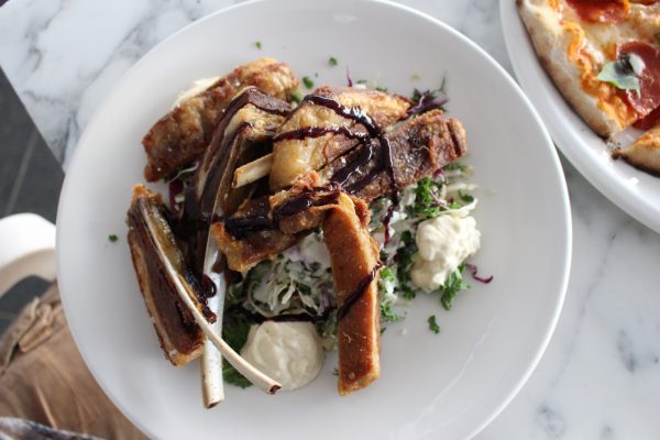 The crispy lamb ribs atop a kale-and-cabbage slaw.